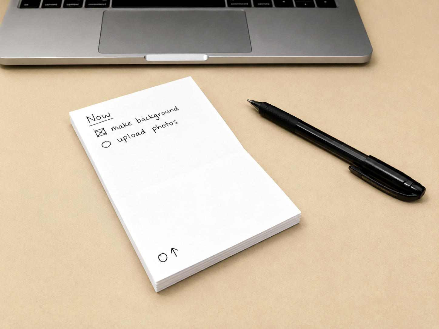 Completed PocketMod booklet beside a black pen on a beige desk.