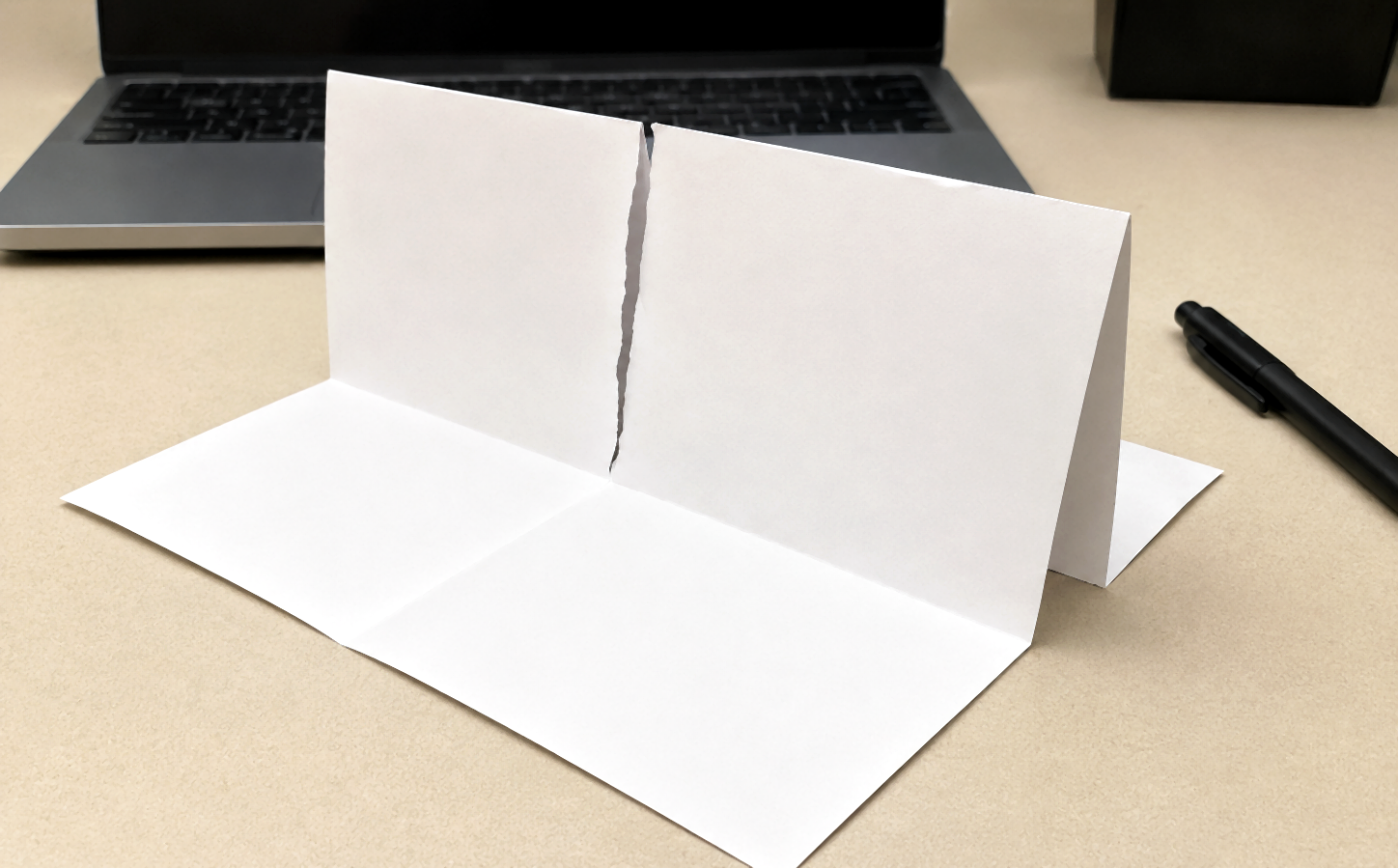 PocketMod sheet standing open with a torn centre slit.
